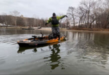 Beginners Guide To Kayak Fishing: Skills & Safety Kayak angler in a drysuit during cold weather tries jumping off his kayak into the water