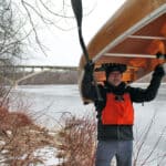 Close Call: How Canoeist Frank Bures Survived An Early-Season Capsize Frank Bures back at the scene of the capsize standing with canoe over his head in the wintertime