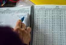 How To Read A Tide Table a person makes handwritten notes while scanning through a spiral bound tide table