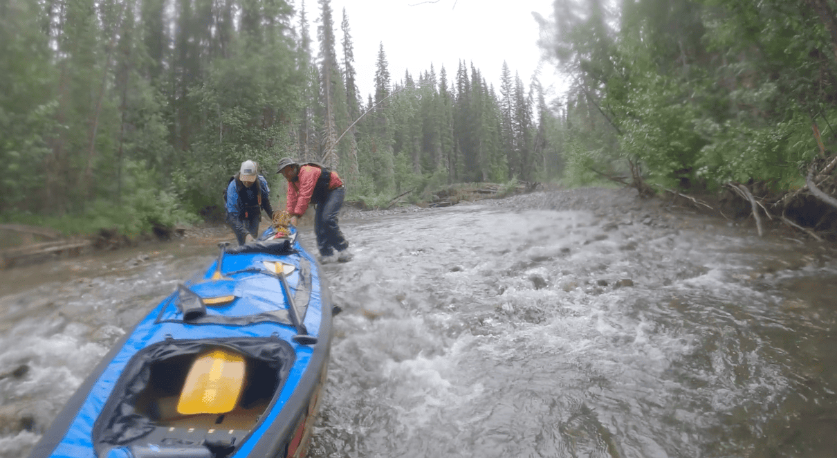 Two people pushing canoe upriver