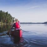 Guide to Canoe Tripping in Québec’s Kipawa Region Two people paddling in red canoe across lake