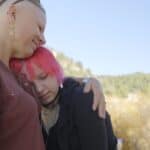 River Mamma Woman hugging her teenage child
