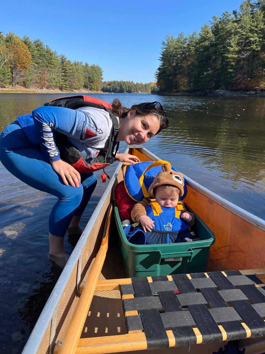 Marissa and Sebastian pose in the canoe with his bucket