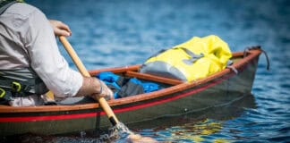 In Defense Of The Goon Stroke man paddles a tripping canoe using the goon stroke