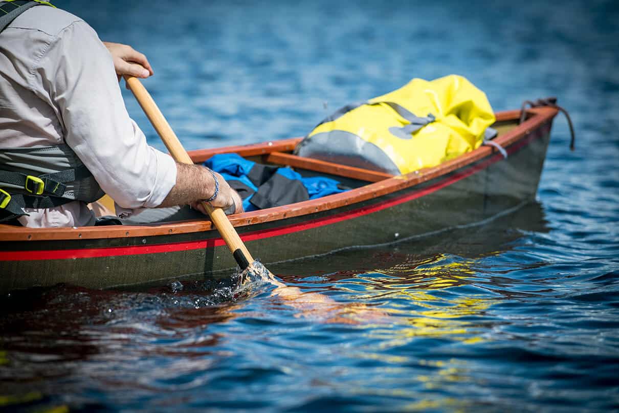 man paddles a tripping canoe using the goon stroke