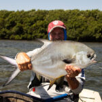 Everything You Need To Know About Catching Permit man holds up a large permit caught while kayak fishing in the Florida Keys