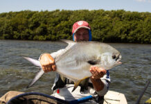Everything You Need To Know About Catching Permit man holds up a large permit caught while kayak fishing in the Florida Keys