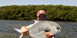 Everything You Need To Know About Catching Permit man holds up a large permit caught while kayak fishing in the Florida Keys