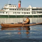 Kayak Review: Melker Värmdö man paddling Melker’s Värmdö kayak with a riverboat in the background