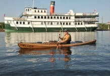 Kayak Review: Melker Värmdö man paddling Melker’s Värmdö kayak with a riverboat in the background