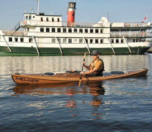 Kayak Review: Melker Värmdö man paddling Melker’s Värmdö kayak with a riverboat in the background