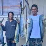 Tiger Shark Attacks Couple on Fishing Kayak in Hawaii Man and woman standing in front of house holding fish