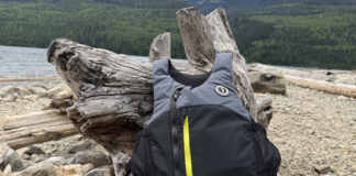 Protected: Kayak Anglers Have A New PFD Option—Here’s What You Need To Know Level 50 PFD from Mustang Survival lying on logs near water.