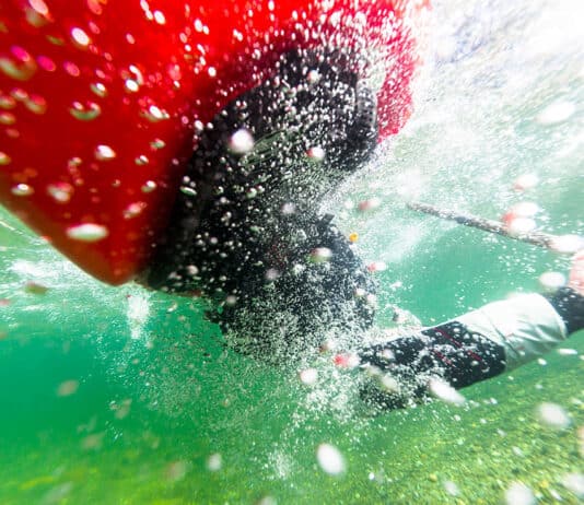 Myth Of The Bombproof Roll underwater photo of a sea kayaker mid-roll