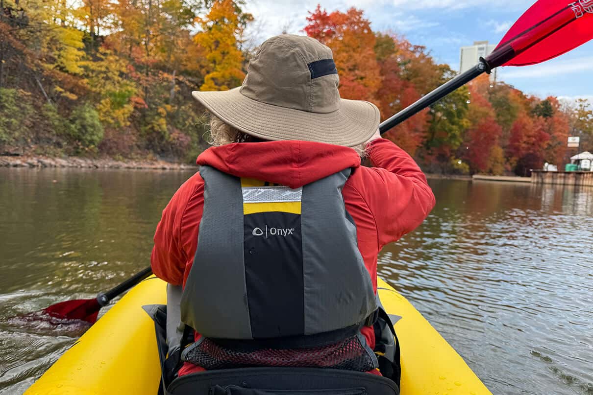 woman paddles a kayak while wearing the Onyx MoveVent PFD