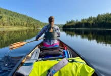 Best Prime Day Deals For Paddlers photo of woman paddling a laden canoe from the stern