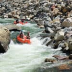 A group of whitewater rafters dropping into a rapid on the Nolichucky River Gorge in Tennessee.