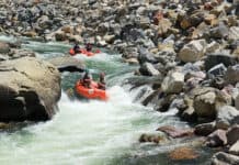 A group of whitewater rafters dropping into a rapid on the Nolichucky River Gorge in Tennessee.