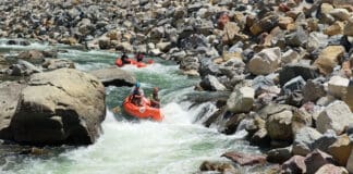 A group of whitewater rafters dropping into a rapid on the Nolichucky River Gorge in Tennessee.