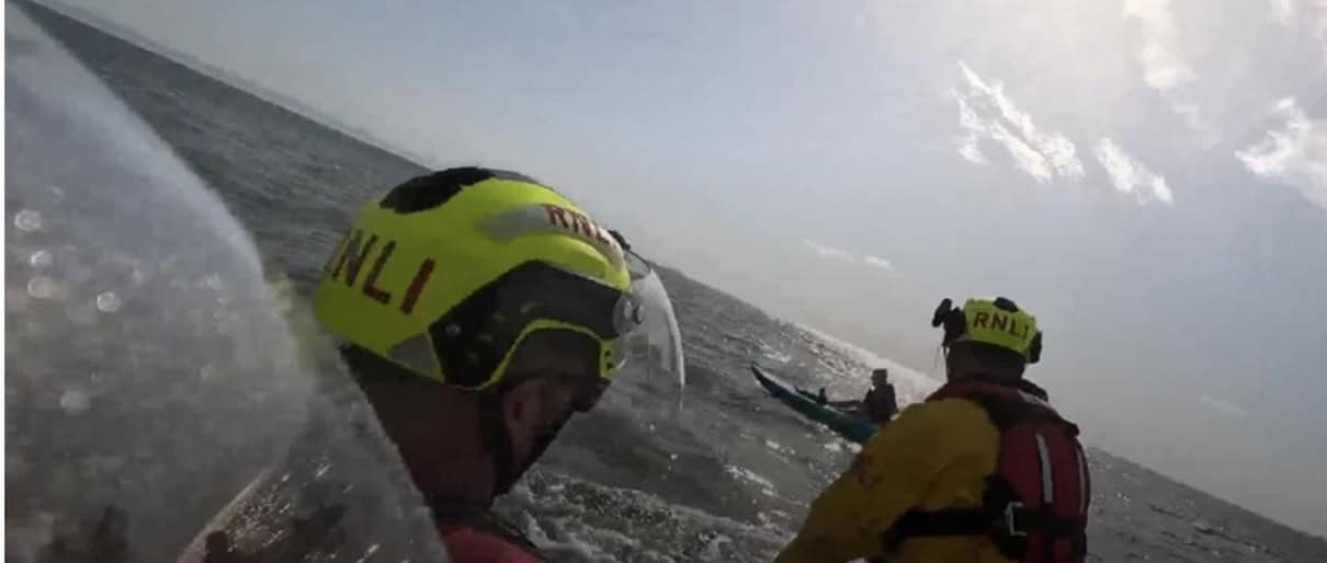 Rescuers approach kayak