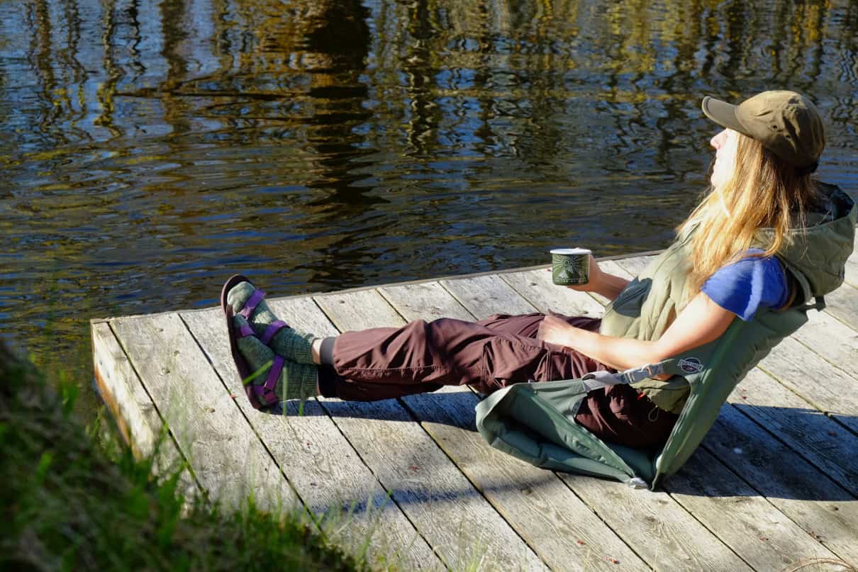 Woman sitting in an Inflatable camp chair on dock.