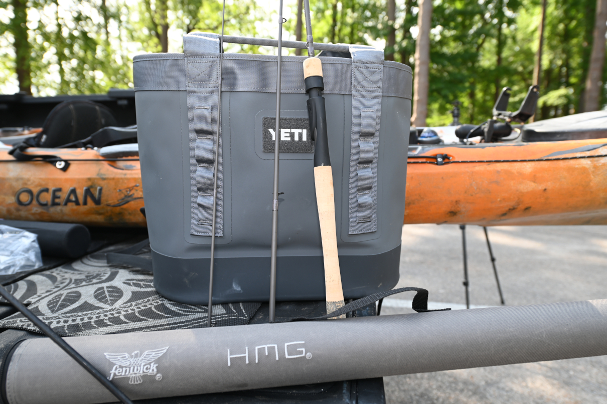 Fenwick fishing rod multi-piece sitting near kayak.