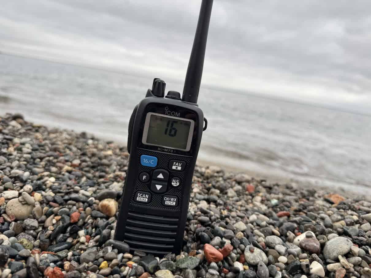 ICOM marine radio on beach near open water.