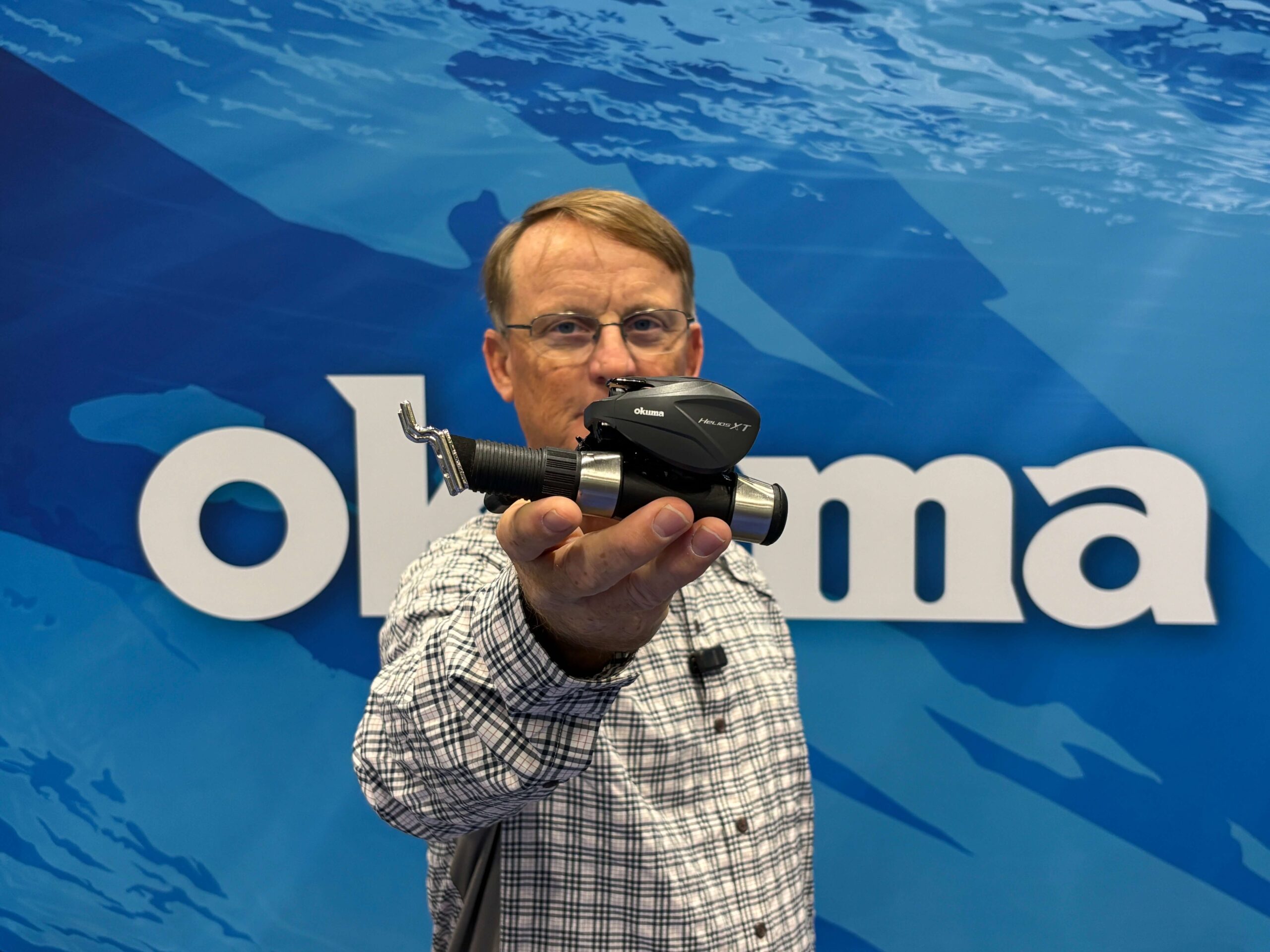 Kayak Angler editor Ric Burnley holes up a Okuma Helios XT reel at ICAST 2026