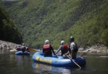 The Guides Who Make Rafting Tennessee Whitewater Unforgettable Guide steering raft down Nolichucky River.