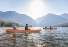 These 6 Montana Lakes Belong On Every Paddler’s Bucket List A group of kayakers on a lake in Montana.