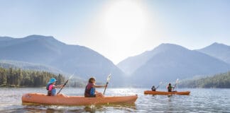 These 6 Montana Lakes Belong On Every Paddler’s Bucket List A group of kayakers on a lake in Montana.