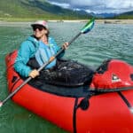 The Basics Of Packrafting A woman paddling a packraft on a scenic and remote river.