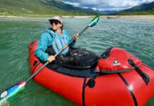The Basics Of Packrafting A woman paddling a packraft on a scenic and remote river.