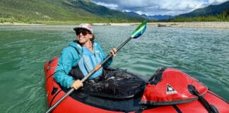 The Basics Of Packrafting A woman paddling a packraft on a scenic and remote river.