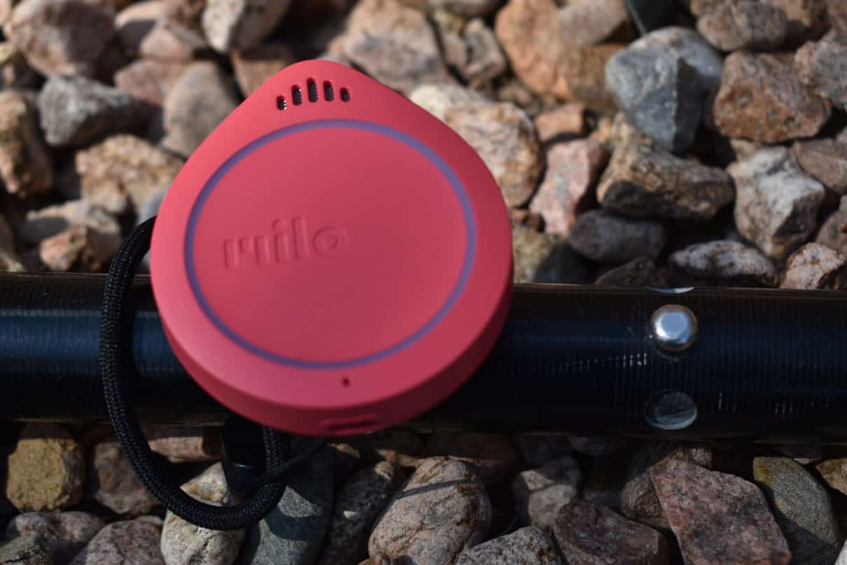 A Milo Action Communicator resting on rocks and a paddle.