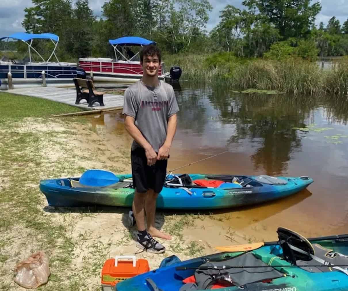 man on beach with kayaks