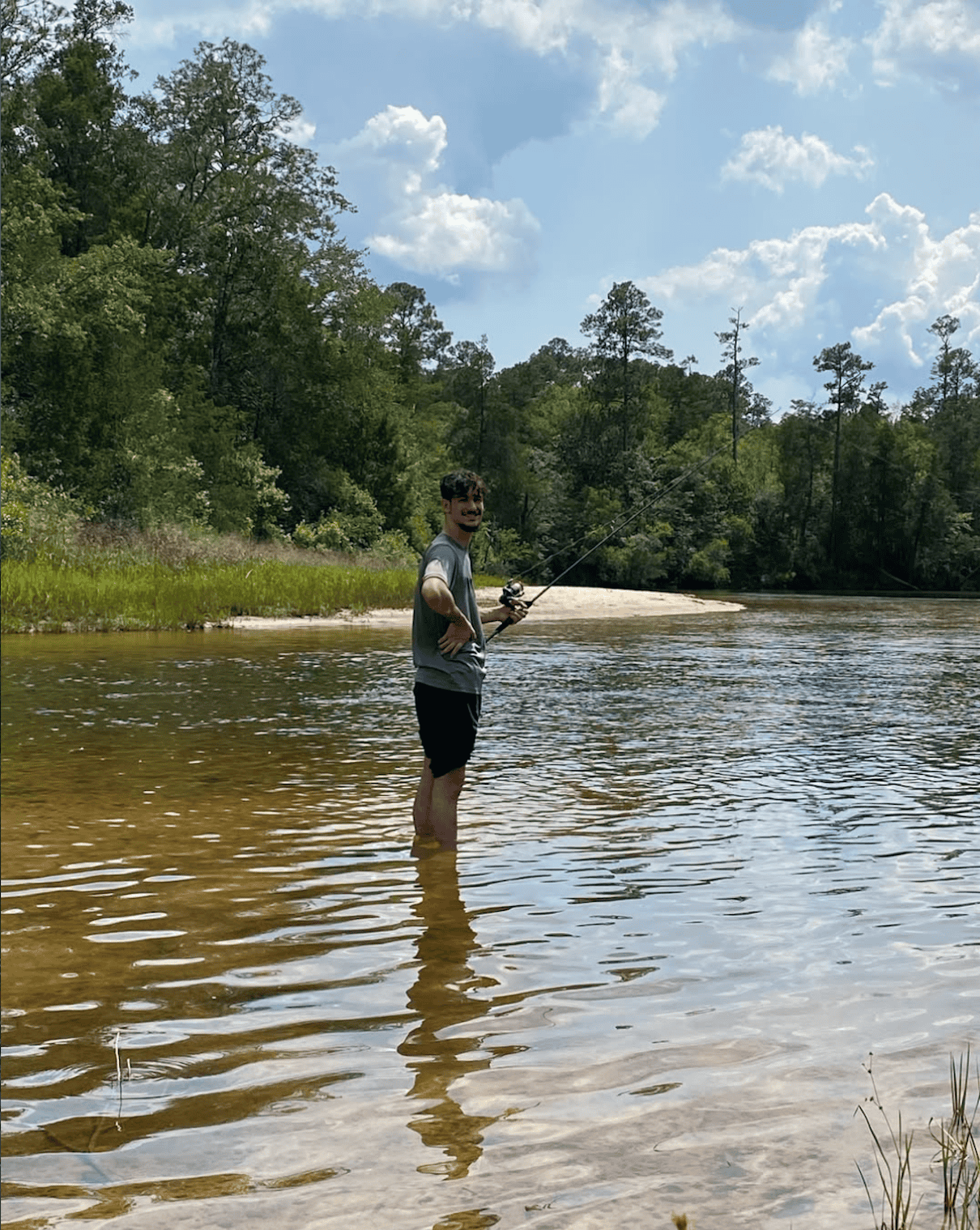 man stands in water fishing