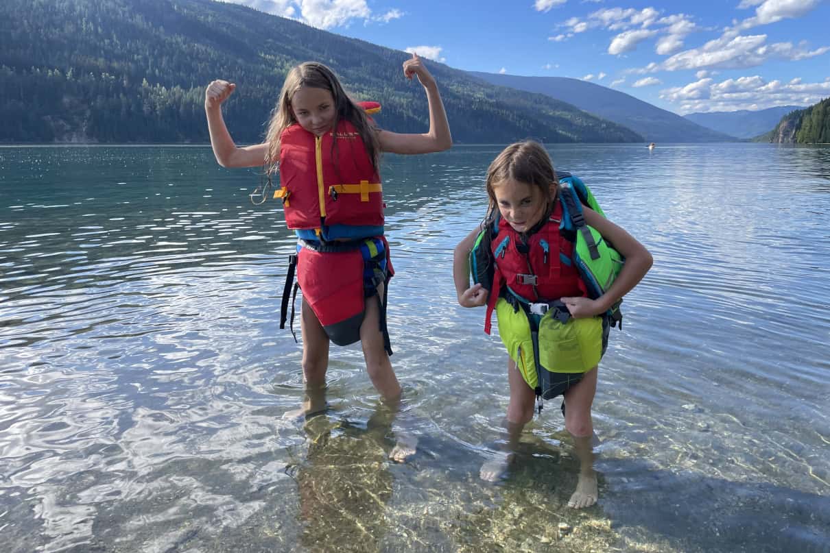Kids wearing life jackets and flexing.