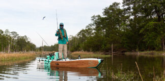 You Should Be Fishing From An Inflatable Kayak a person stands and pitches a lure from a BOTE inflatable kayak