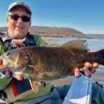 Take Your River Fishing To The Next Level Jeff Little poses with a smallmouth bass caught while kayak fishing on a river