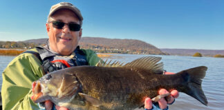 Take Your River Fishing To The Next Level Jeff Little poses with a smallmouth bass caught while kayak fishing on a river