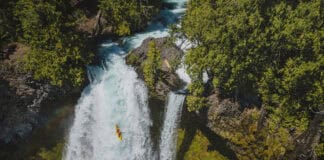Is Making Whitewater More Accessible Killing Its Appeal? whitewater kayaker drops a large waterfall