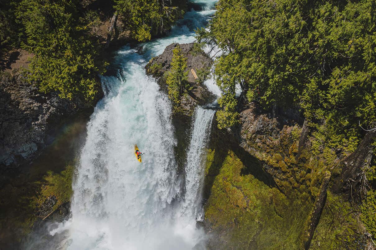 whitewater kayaker drops a large waterfall