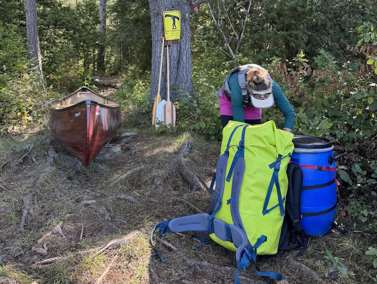 woman with MEC Slogg dry bag and canoe barrel
