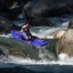 Enter To Win A Kokatat Hydrus Drysuit woman wearing Kokatat drysuit paddles a whitewater kayak through rapids