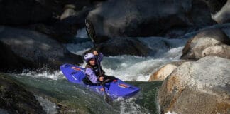Enter To Win A Kokatat Hydrus Drysuit woman wearing Kokatat drysuit paddles a whitewater kayak through rapids