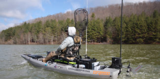 Person on a fishing kayak converted to a motor/pedal drive
