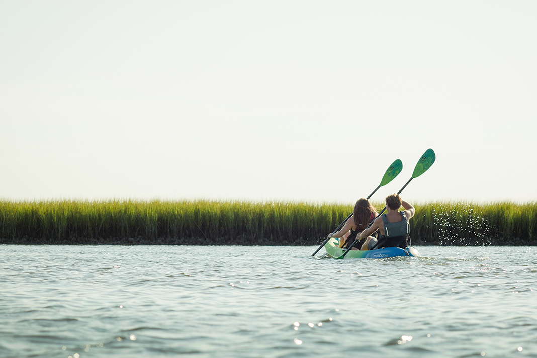 Two people paddling a sit-on-top tandem kayak